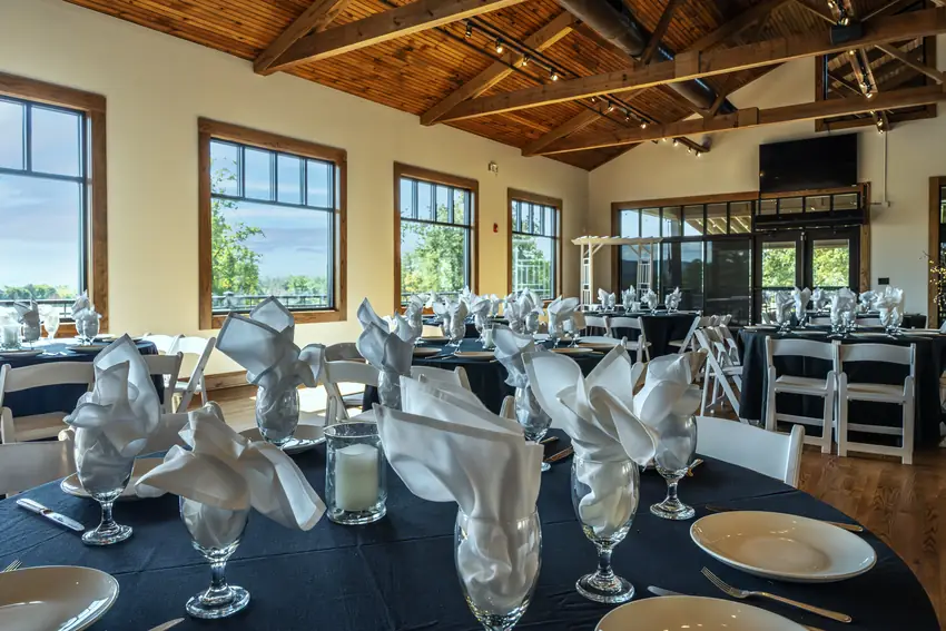 Round tables with navy linens and folded white napkins set for a seated dinner