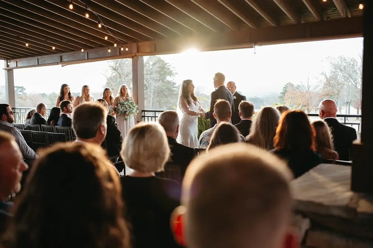 Sunset wedding ceremony on the covered deck overlooking the golf course in Taylorsville, NC
